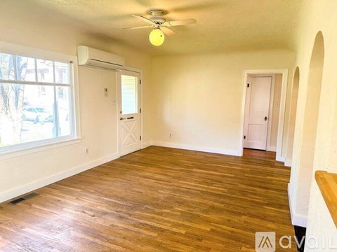 A room with wooden floors and a ceiling fan.