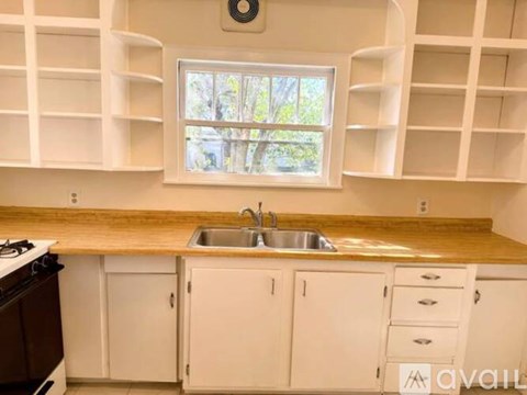A kitchen with white cabinets and a wooden countertop.
