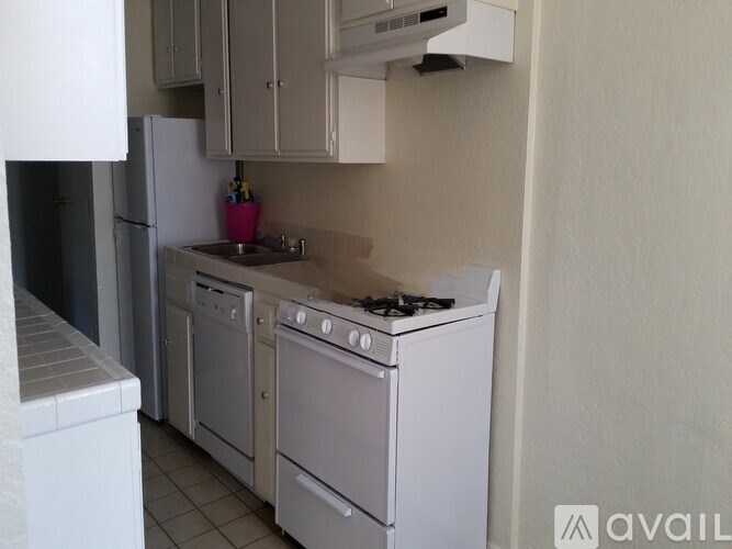 A kitchen with white appliances and a pink container on the counter.