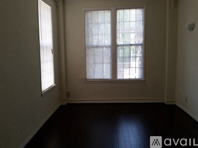 A room with a large window and a wooden floor.