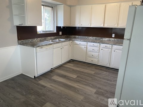 A kitchen with white cabinets and a dark countertop.