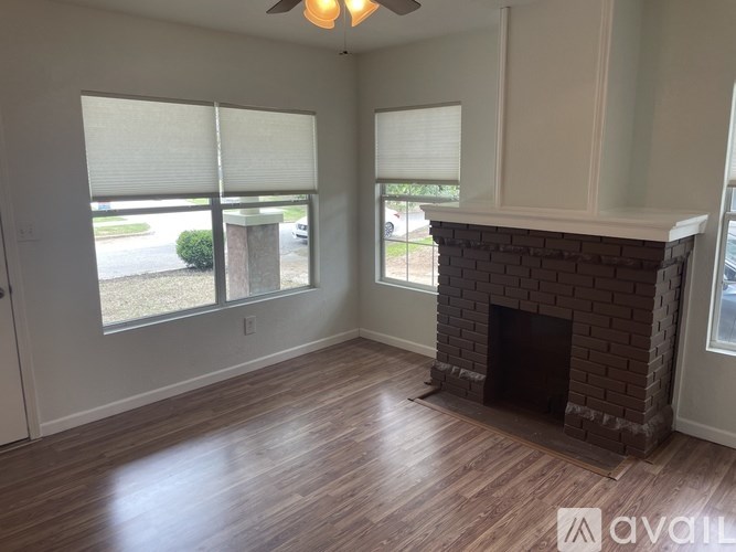 A room with a fireplace and wooden flooring.