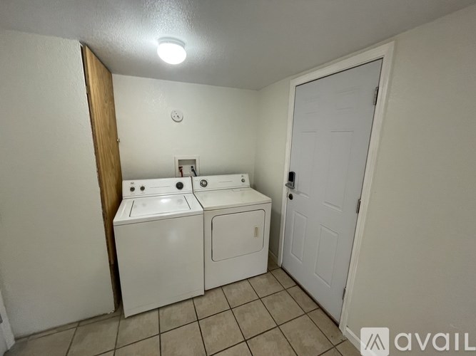 A bathroom with a toilet, sink, and a door.