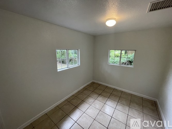A room with a window and tiled floor.