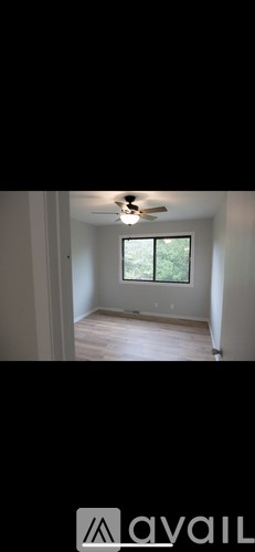 A room with a window and a ceiling fan.