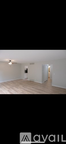 A room with wooden flooring and a ceiling fan.