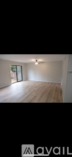 A room with wooden flooring and a window.