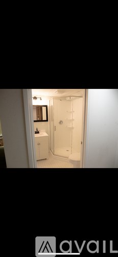 A bathroom with a white door and a mirror on the wall.