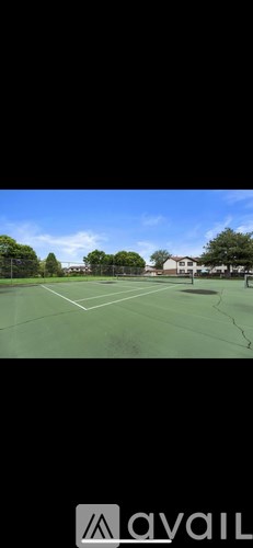A tennis court with a net and a building in the background.