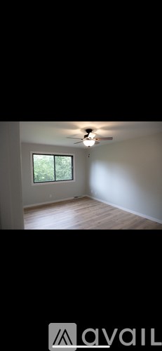 A room with a ceiling fan and a window.