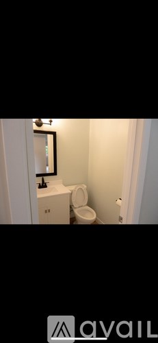 A bathroom with a toilet and a mirror.