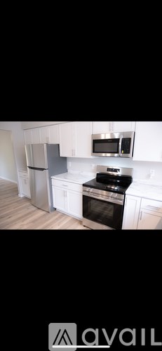 A kitchen with white cabinets and a black stove top oven.