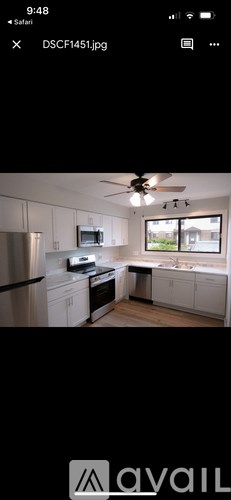 A modern kitchen with white cabinets and stainless steel appliances.