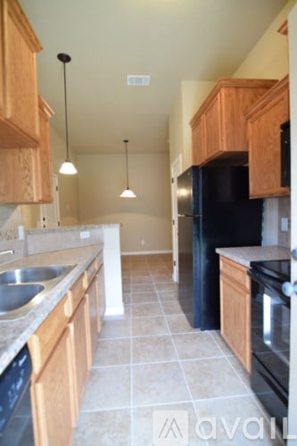 A kitchen with wooden cabinets and black appliances.