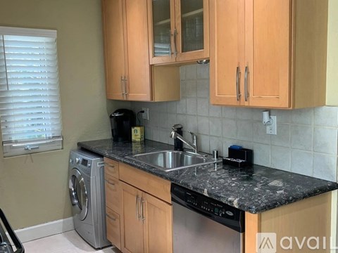 A kitchen with wooden cabinets and a black granite countertop.
