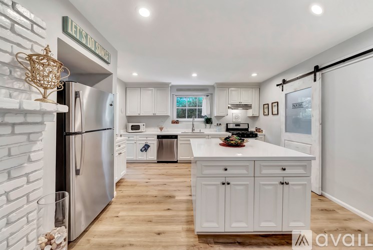 A kitchen with white cabinets and a refrigerator with a sign that says "Let's Do It Service.".