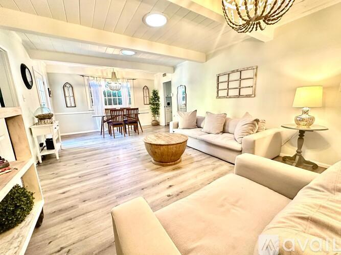 A living room with a white couch and a wooden floor.