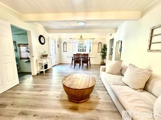 A living room with a white couch and a wooden coffee table.