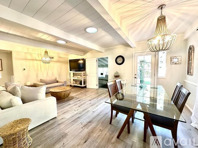 A well-lit, spacious dining area with a glass table and chairs.