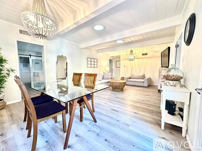 A dining room with a glass table and chairs.