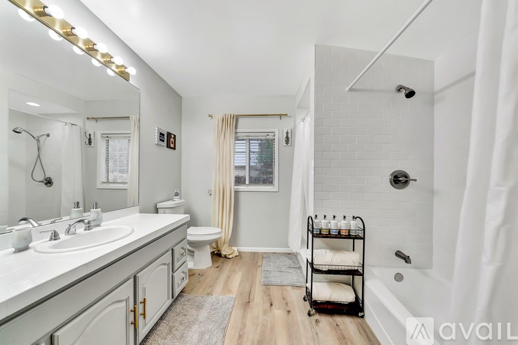 A bathroom with a white tile shower and a white sink.