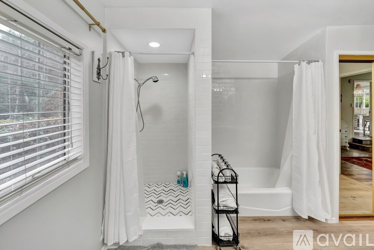 A bathroom with a white shower curtain and a white bathtub.