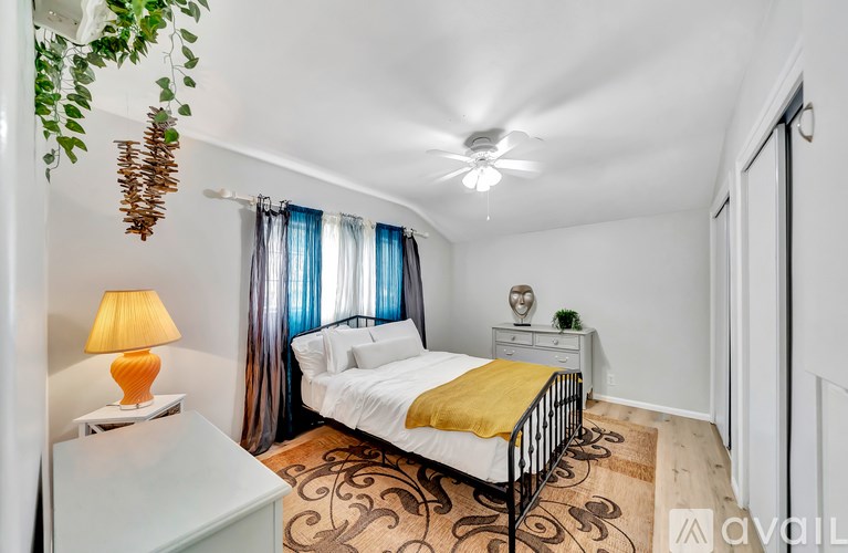 A bedroom with a bed, nightstand, and lamp.