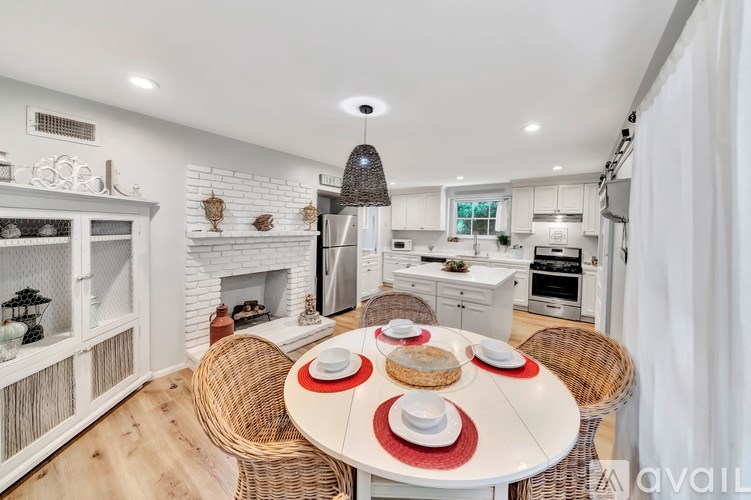 A dining room with a white table and chairs.