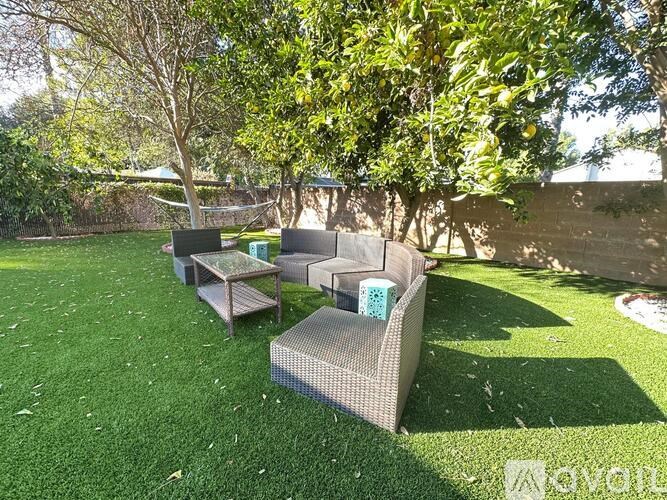 A backyard with a lawn and patio furniture.
