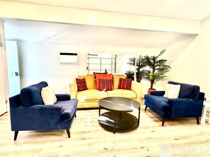 A living room with blue chairs and a yellow couch.