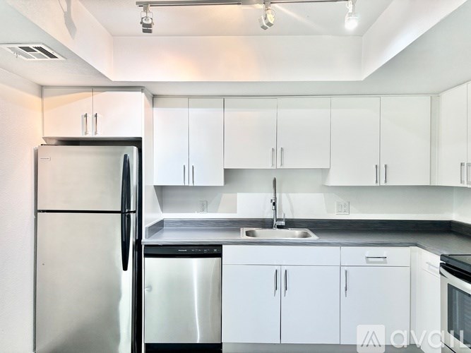 A kitchen with white cabinets and a stainless steel refrigerator.