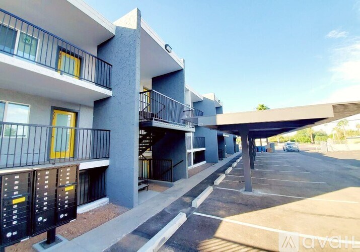 A modern apartment complex with a parking lot in front.