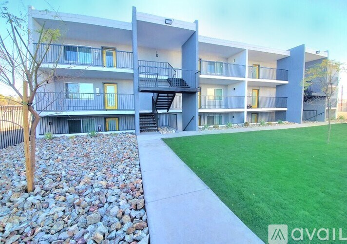 A modern apartment complex with a stone pathway leading to the entrance.
