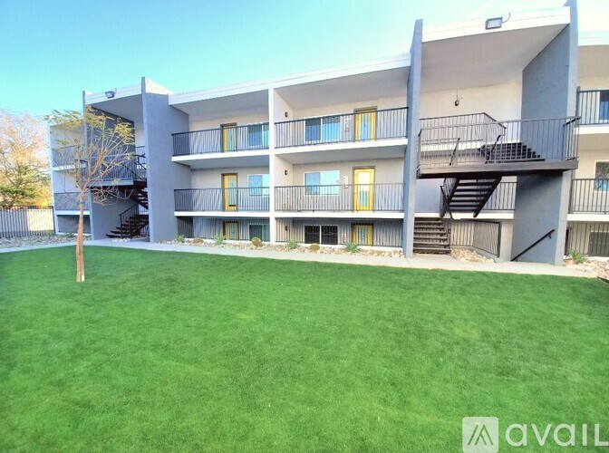 Apartment complex with green lawn in front.
