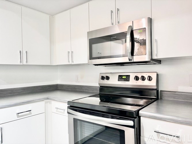 A modern kitchen with a stove and microwave above it.