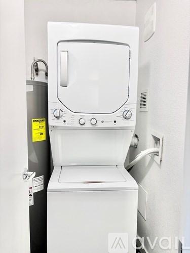 A white toilet with a tank and a wall-mounted pipe.