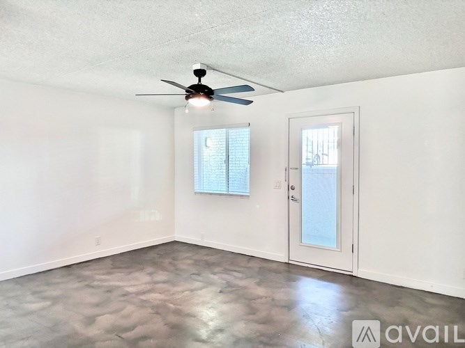 A room with a ceiling fan and a door leading to a balcony.