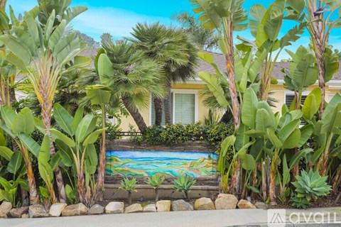 A pool surrounded by green plants and trees.