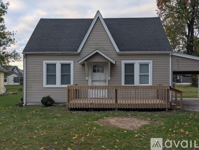 A house with a grey roof and a wooden porch.