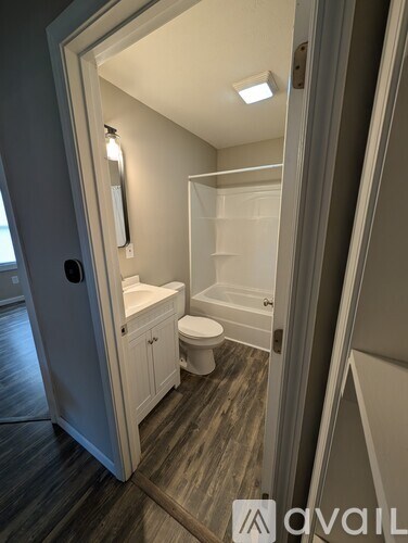 A bathroom with a toilet, sink, and shelves.