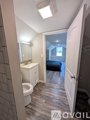 A bathroom with a toilet, sink, and mirror.