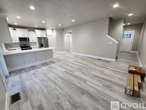 A spacious kitchen with white cabinets and a grey floor.