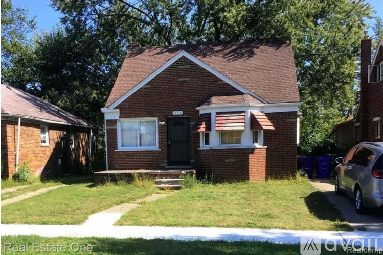 A small brick house with a black door and a flag on the front.