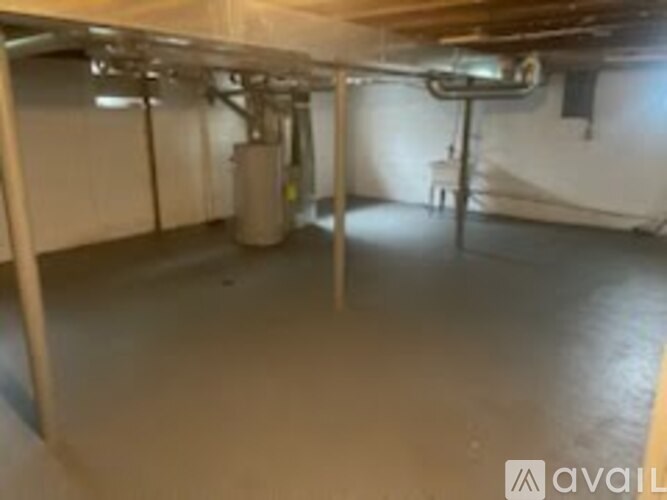 A spacious basement with a concrete floor and white walls.