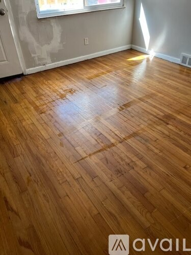 A room with wooden flooring and a window.