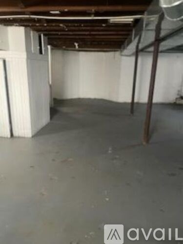 A room with a white wall and a wooden beam on the ceiling.