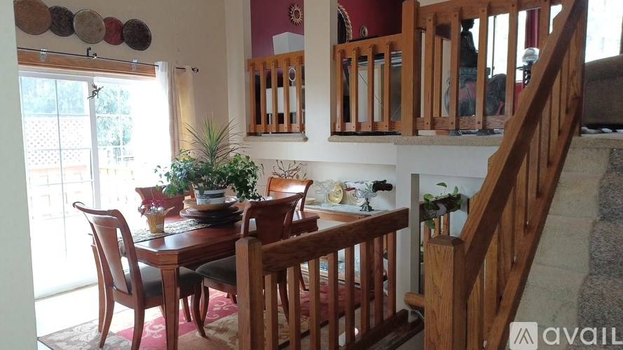 A dining room with a wooden table and chairs.