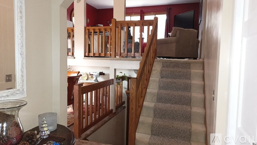 A staircase with a carpeted runner leads up to a second floor.
