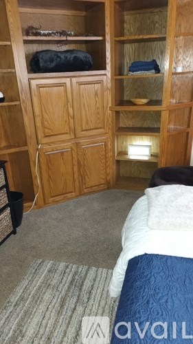 A bedroom with a bed, a wardrobe, and a shelf.