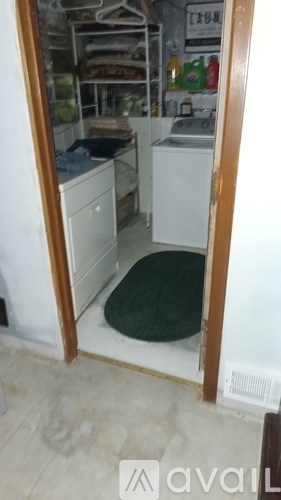 A small kitchen with a refrigerator, sink, and cabinets.